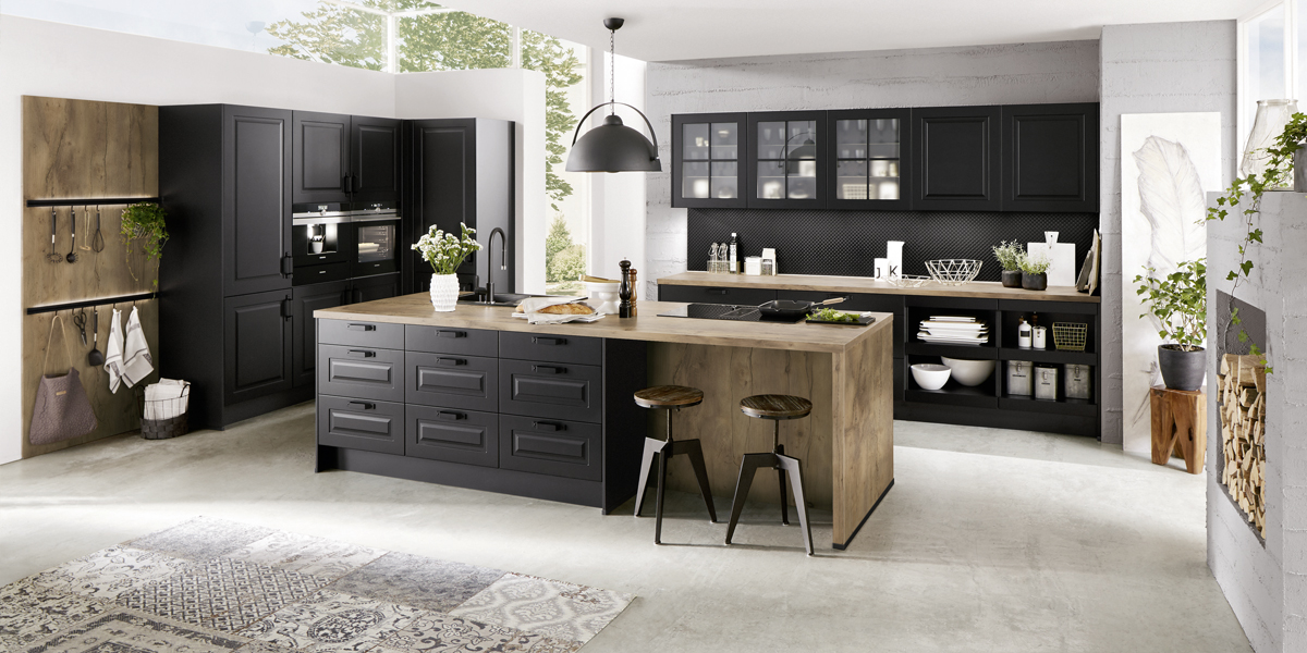 Die charakteristischen Rahmenfronten werden neu interpretiert und erscheinen jetzt in geradlinigem Design. Sie harmonieren perfekt mit modernen Industriedesign-Elementen, die coole Akzente setzen. Lackoberflächen in dunklen Schwarz- und Anthrazittönen und Griffe aus Edelstahl verleihen Ihrer Küche eine sachlich-technische Note und bilden einen spannenden Kontrast zu Accessoires aus natürlichen Materialien. 